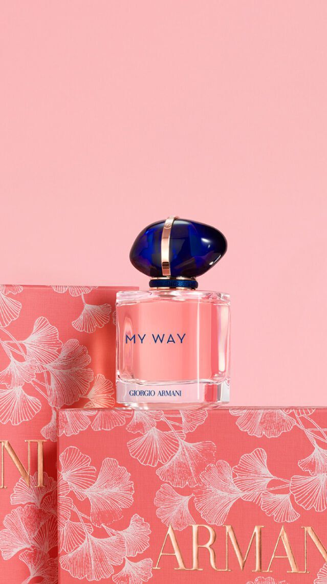 Frascos de perfume "My Way" de Armani sobre un fondo rosa, con un diseno floral en la caja.
