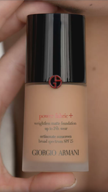 A close-up of a bottle of Giorgio Armani Power Fabric+ foundation, showcasing its sleek design and branding.