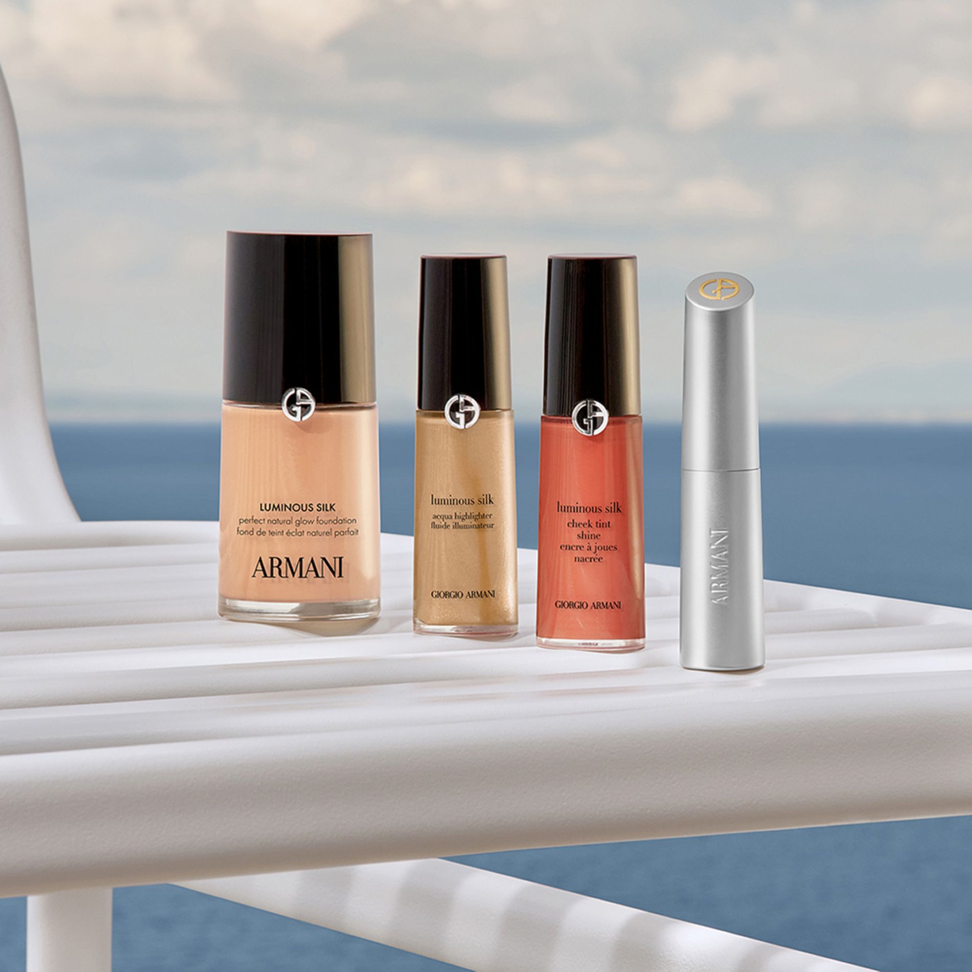 Un ritual de belleza sofisticado: Base Luminous Silk, Corrector, Colorete y un labial plateado. Sobre un yate frente al mar, estos iconos prometen un resplandor natural y ligero para una escapada de lujo con elegancia absoluta.