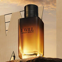 Frasco de perfume I Will de Giorgio Armani, con tonos ambar y dorados, sobre un fondo de cielo al atardecer