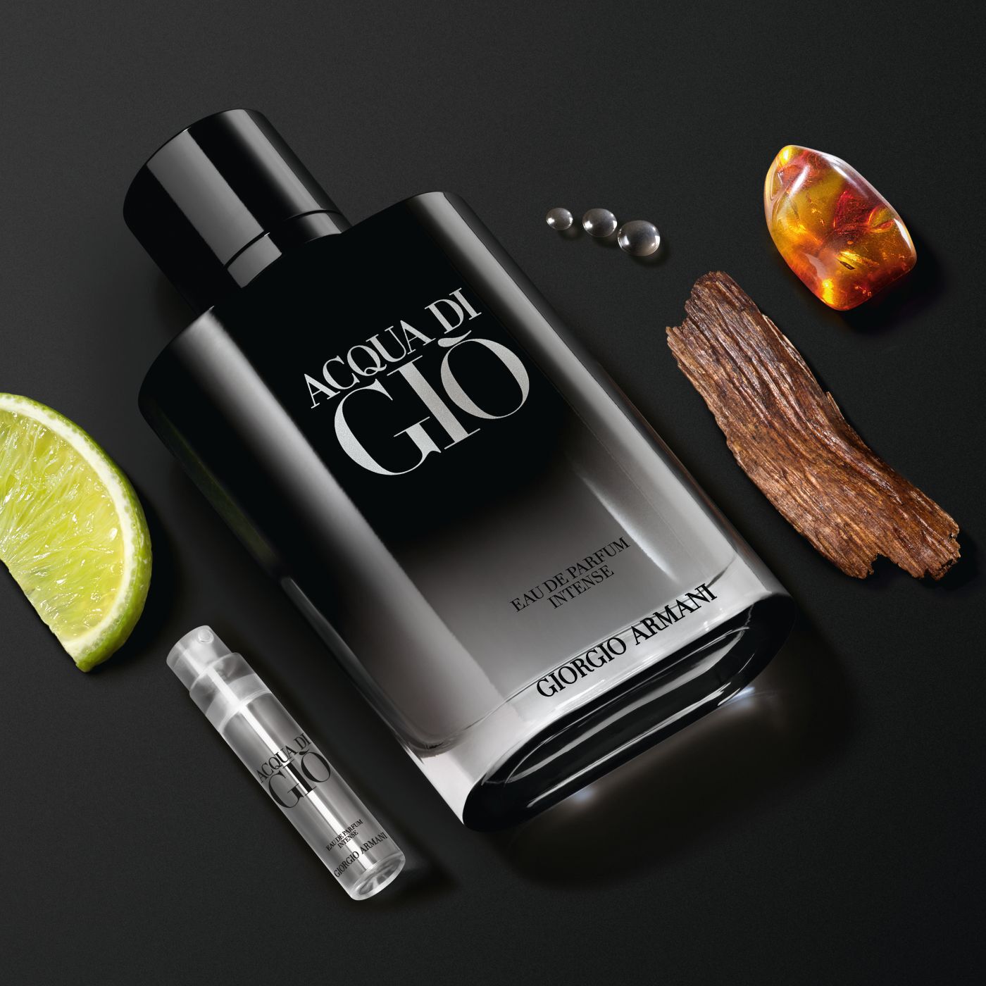 Frasco de Acqua di Gio Eau de Parfum Intense con lima, madera, ambar y muestra sobre fondo negro.