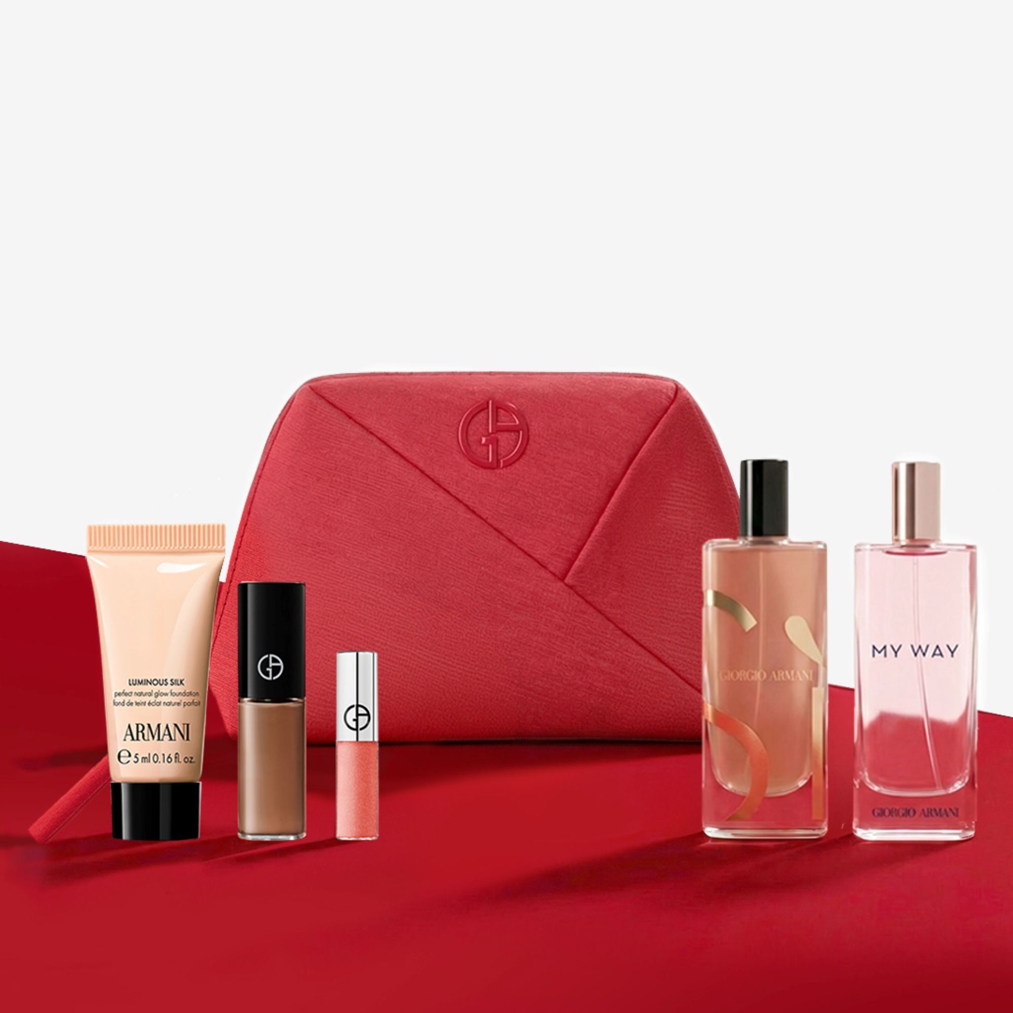 Set de belleza Giorgio Armani con neceser rojo, perfumes y maquillaje.