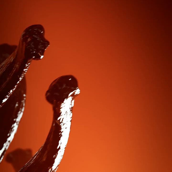 A perfume bottle for "EMPORIO ARMANI STRONGER WITH YOU SPICES" scent, featuring a warm, amber-toned bottle with a metallic cap. It is artfully arranged with vanilla pods and saffron threads against a vibrant red-orange background, highlighting the aromatic spices.