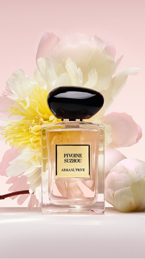 Armani/Prive Pivoine Suzhou: un frasco con una fragancia rosa suave, entre exuberantes peonias blancas y amarillas, celebrando la gracia y el resplandor radiante de la naturaleza.