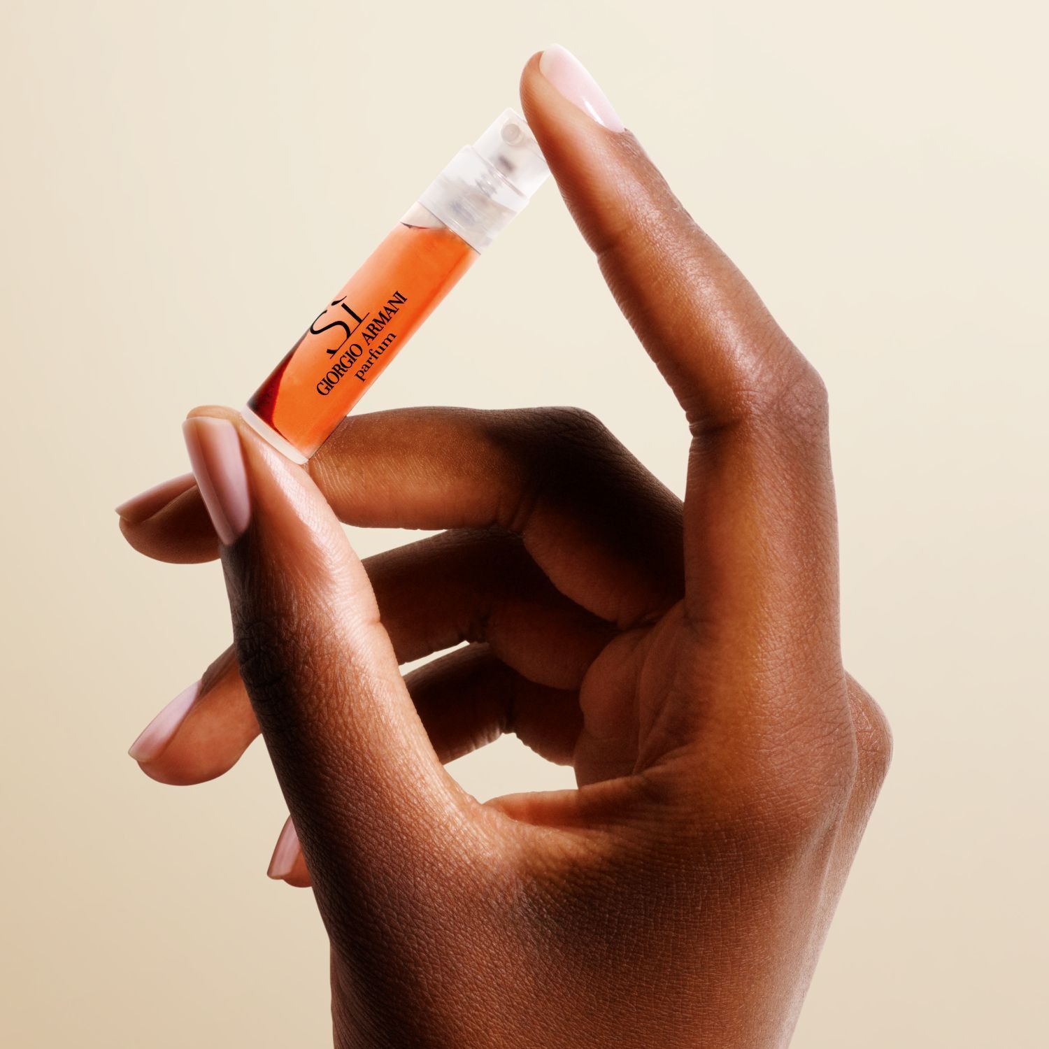 Una mano sosteniendo un vial de muestra del perfume Si de Giorgio Armani.