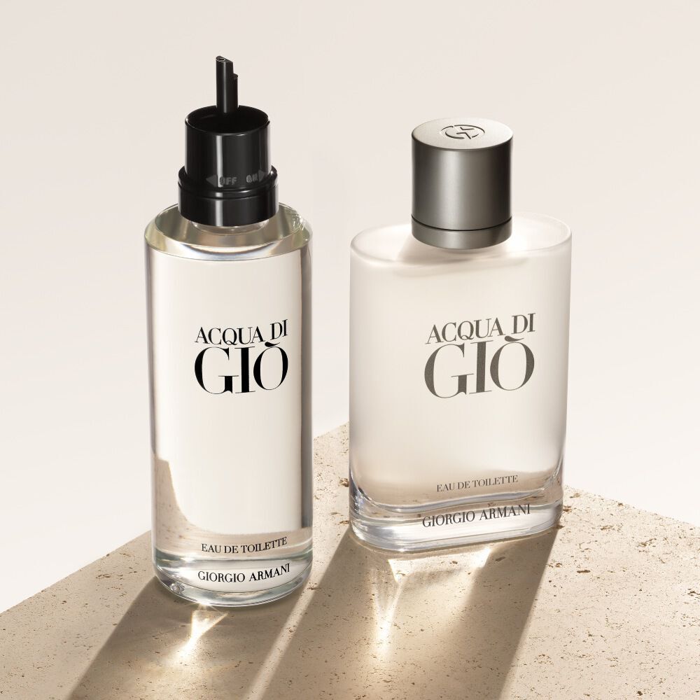 Dos frascos de Acqua di Gio Eau de Toilette, la recarga a la izquierda, se presentan sobre un fondo texturizado de color beige.