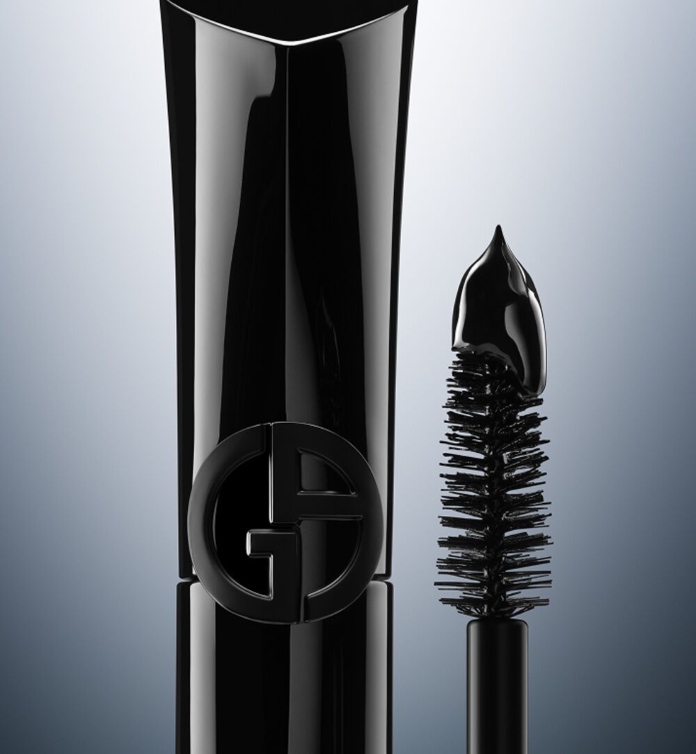 Giorgio Armani Vertigo Drama mascara in sleek black packaging, shown with its curved brush on a grey gradient background.