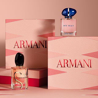 Frascos de las fragancias Si y My Way de Giorgio Armani junto a cajas de regalo rosas de la marca.