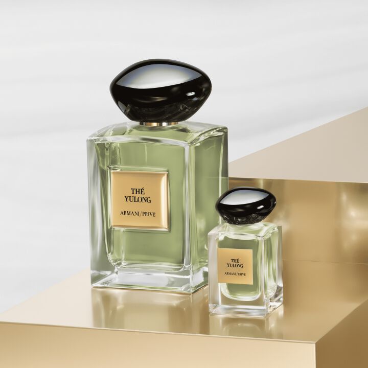 Dos frascos de perfume Armani Prive The Yulong sobre un soporte dorado.