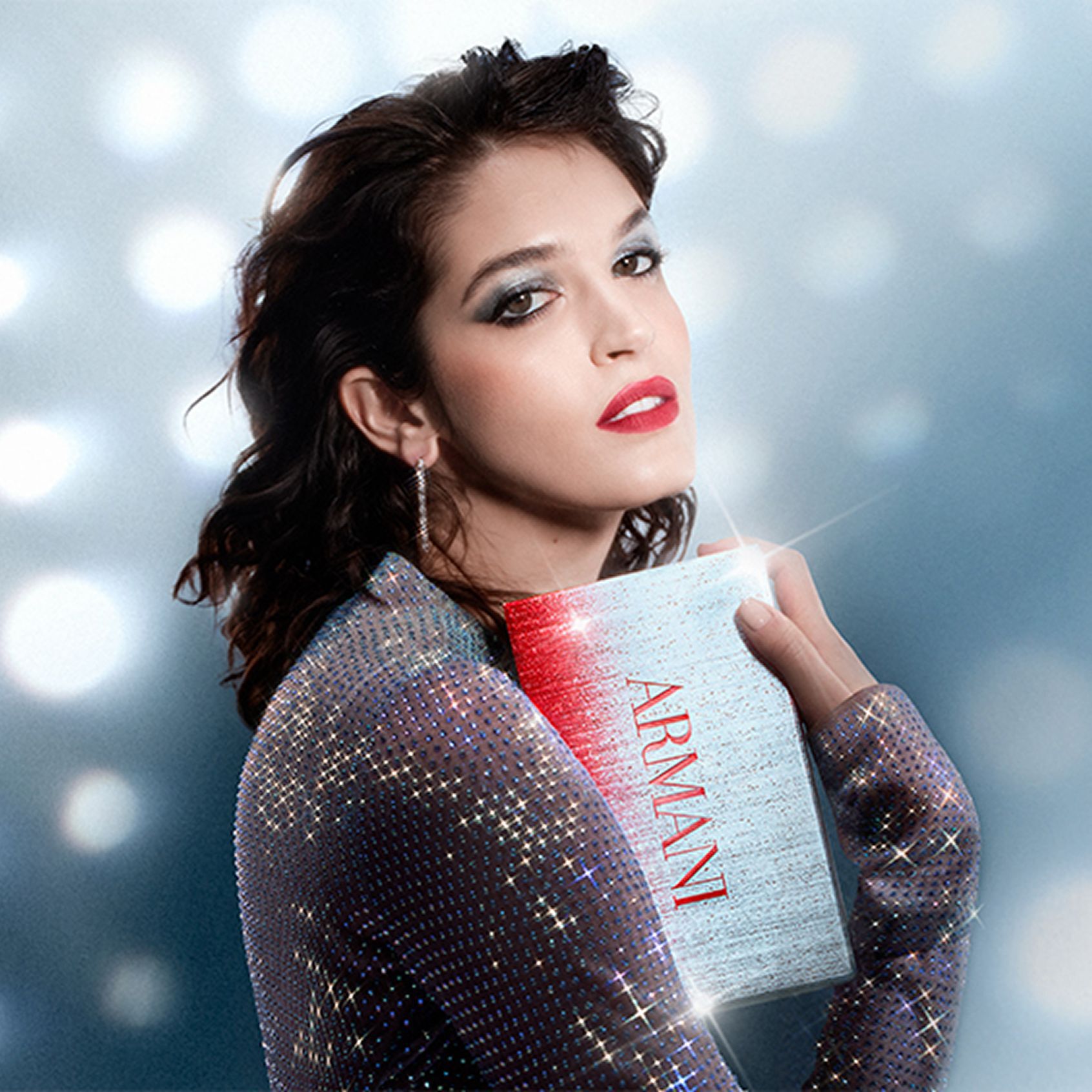 Una hermosa mujer con un look de maquillaje navideno sostiene una caja de regalo, sobre un fondo de puntos de luz de ensueno estilo disco.