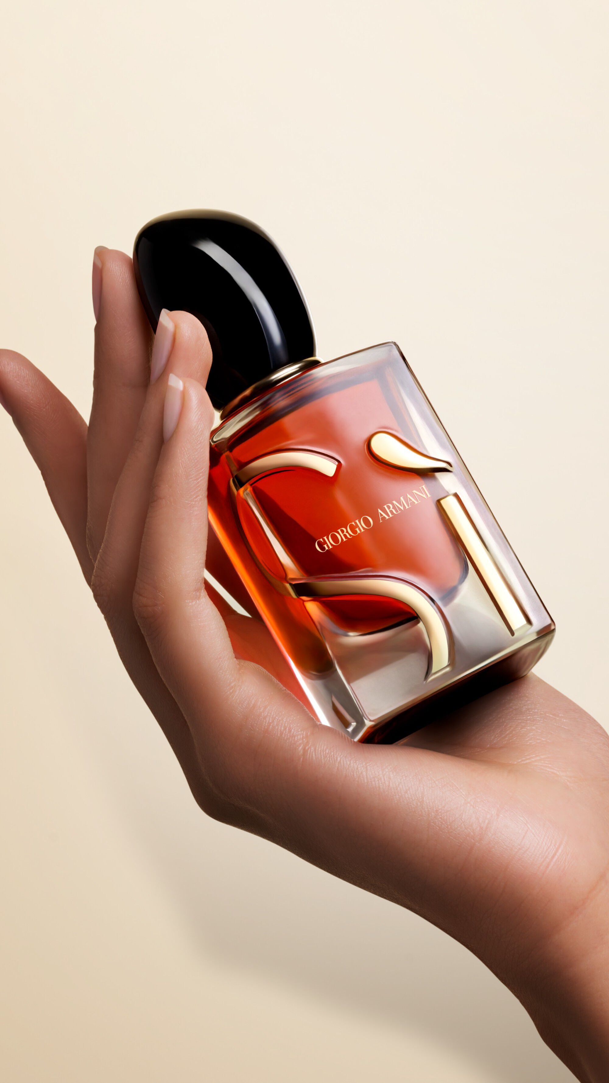 Una mano sosteniendo un frasco de SI PARFUM