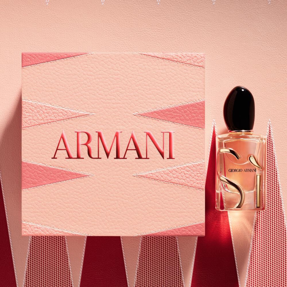 Armani Si Eau de Parfum bottle and cap from the Mother’s Day gift set on a pink and red geometric backgammon background.