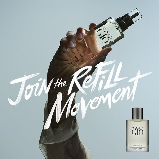 Un visual impactante: una mano sostiene la recarga de Acqua di Gio frente al cielo, con el mensaje "Join the Refill Movement". Simbolo del lujo sostenible y la frescura marina eterna de la Casa Armani.