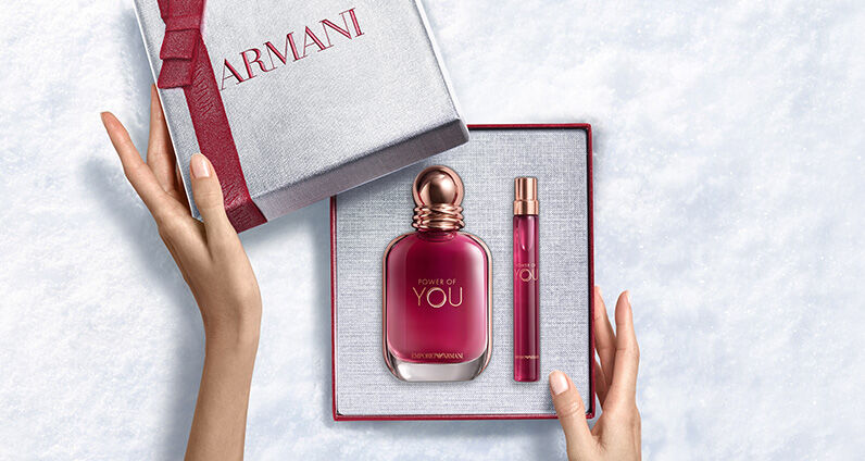 Frasco de perfume Giorgio Armani "Si" junto a una gran caja de regalo Armani rosa texturizada.