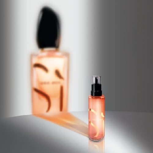 Frascos de perfume 'Sí' de Giorgio Armani, destacando su elegante diseño y tonalidades cálidas.