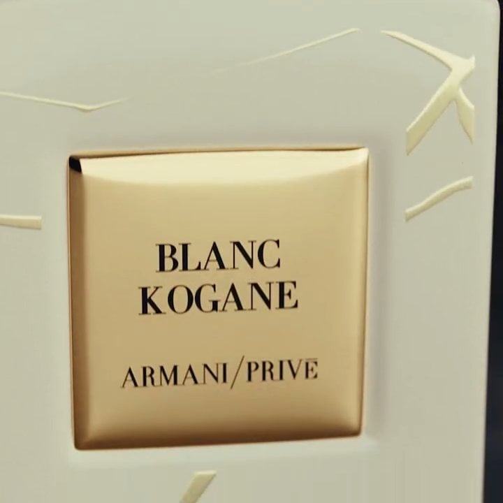 Botella de perfume Armani Privé Blanc Kogane con etiqueta dorada sobre fondo claro.