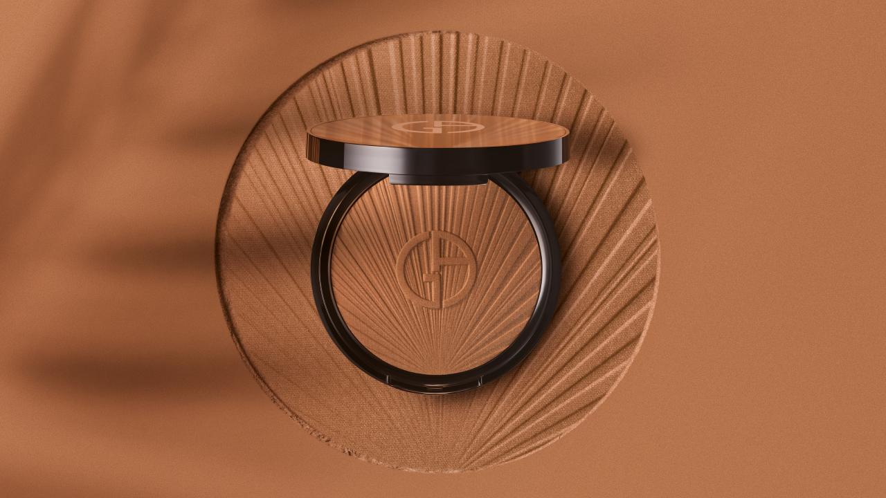 Compacto de maquillaje en tonos marrones, con logotipo de la marca, sobre fondo texturizado claro.