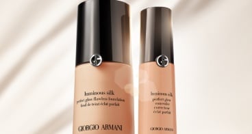 Botellas de base Luminous Silk de Giorgio Armani sobre un fondo blanco con un diseño rojo en la parte inferior.